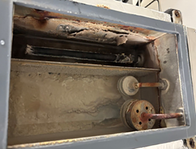Steam generator unit after 18 months of using suboptimal water, showing mineral buildup and demonstrating the importance of environmental chamber repair. 